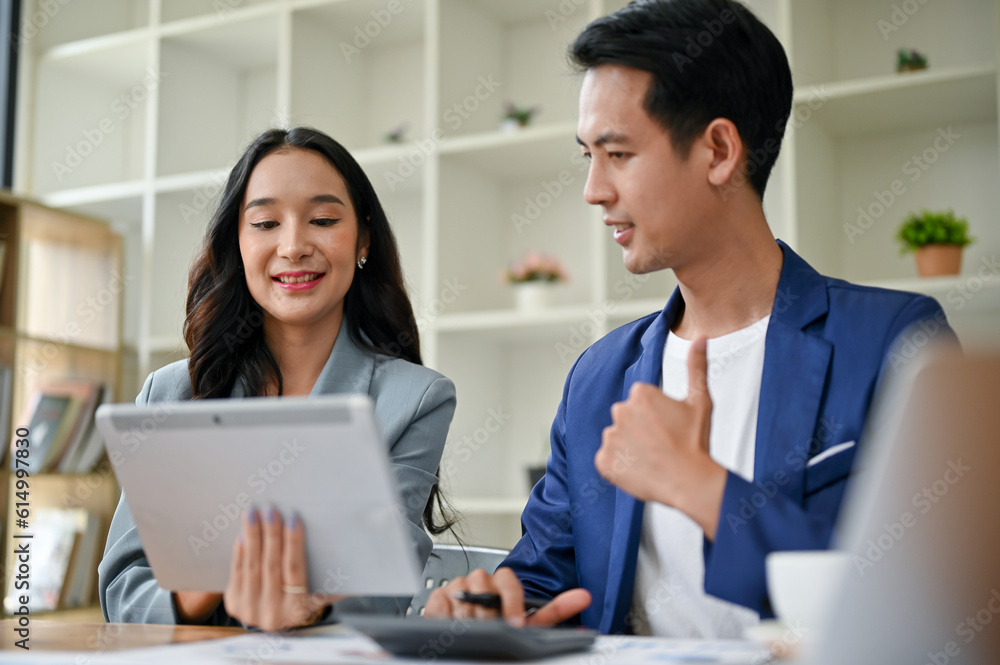 A smart businessman is giving a thumb up to a female colleague while working together. A smart businessman is giving a thumb up to a female colleague while working together.