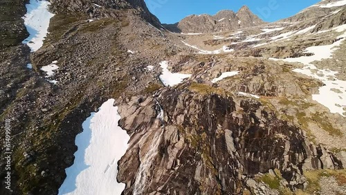 FPV drone footage following a stream made from melting snow up the stunning peaks in northern Norway