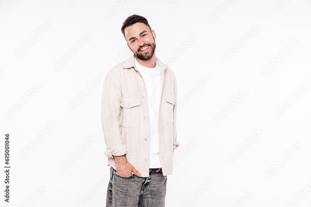 Portrait of handsome smiling stylish hipster lambersexual model. Sexy man dressed in white T-shirt and jeans. Fashion male isolated on white background in studio Portrait of handsome smiling stylish hipster lambersexual model. Sexy man dressed in white T-shirt and jeans. Fashion male isolated on white background in studio