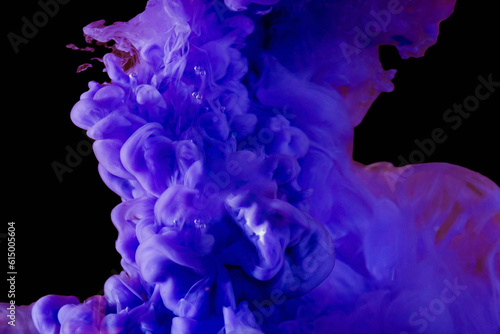 Abstract whirlwind,swirl purple acrylic ink in water.Fluid drop.Paint water.Bright blue purple color ink smoke cloud floating on isolated dark background.Close-up.