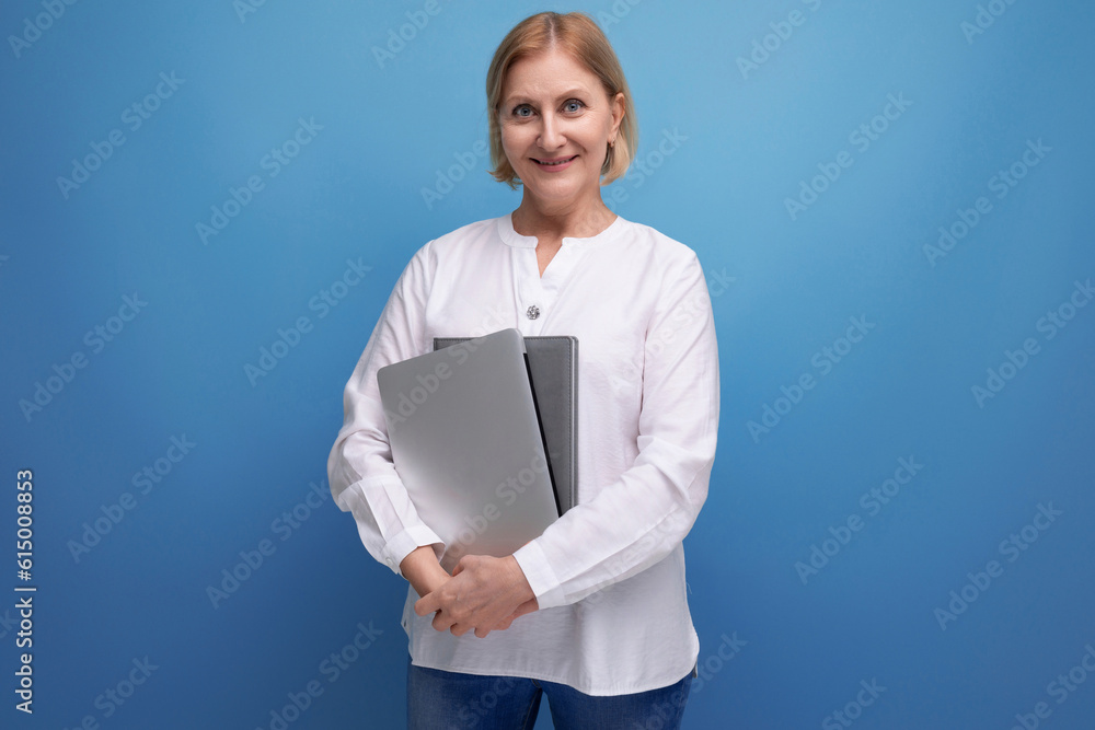serious adult woman with blond hair working remotely using laptop serious adult woman with blond hair working remotely using laptop