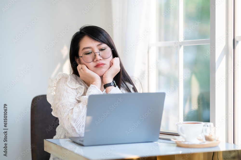 Portrait of displeased upset frustrated frowning asian female freelance people business female looking casual working with laptop computer with coffee cup and smartphone in coffee shop. Portrait of displeased upset frustrated frowning asian female freelance people business female looking casual working with laptop computer with coffee cup and smartphone in coffee shop.