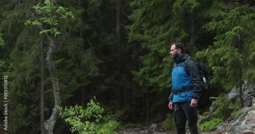 A fit young man is walking alone on a rocky terrain, coming out of the forest. The concept of a man traveling alone. A fit young man is walking alone on a rocky terrain, coming out of the forest. The concept of a man traveling alone.