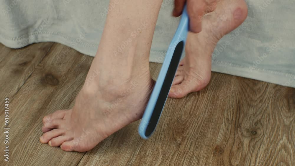 The female uses a sanding brush to exfoliate her foot. Treatment of ...