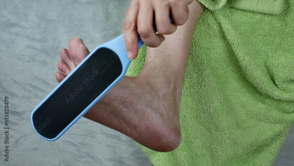 Video „The girl cleans the heels of the feet with a grater for the skin