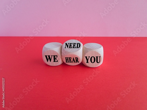 We need and hear you symbol. Turned the wooden cube and changes words we need you to we hear you. Beautiful pink background, copy space. Business, support we need and hear you concept.