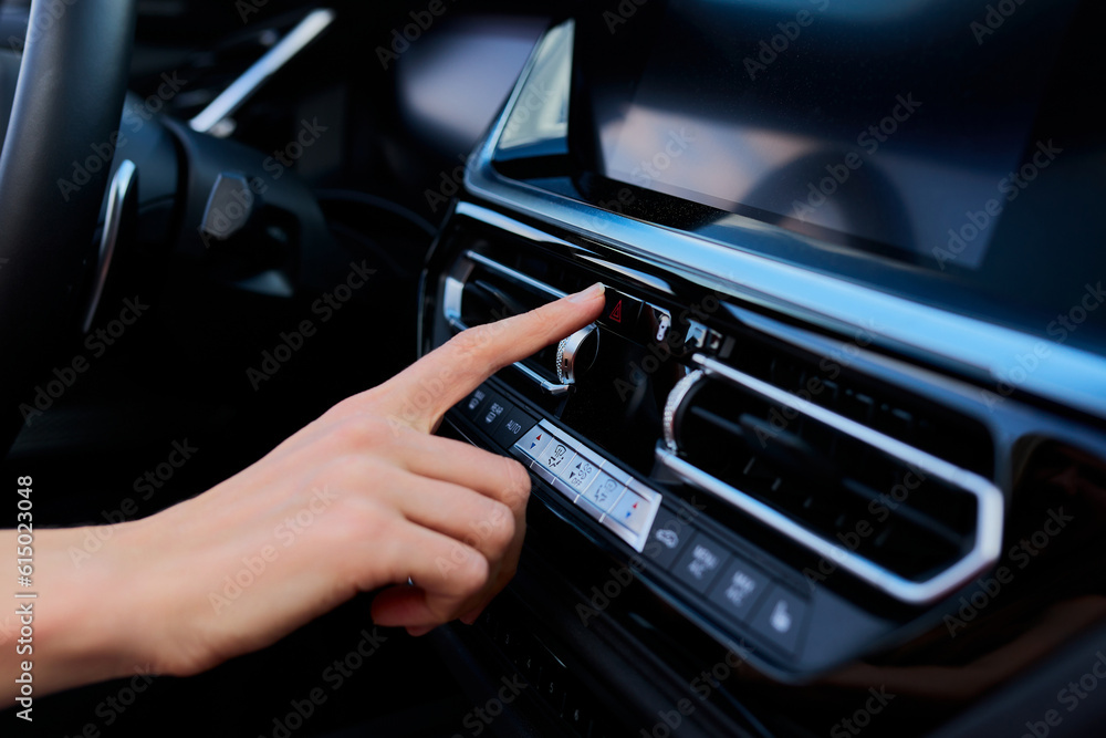 Close-up of a woman's hand pressing the emergency button in the car. Emergency stop. Modern car