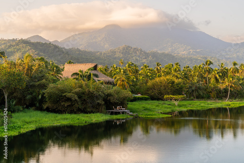 landscape with lakeside house river and big mountains with tropical palm forest in sierra nevada de santa marta parque tayrona  photo
