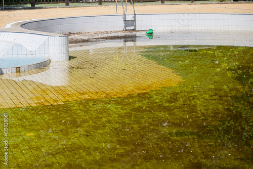 abandoned swimming pool with dirty and stagnant water photo