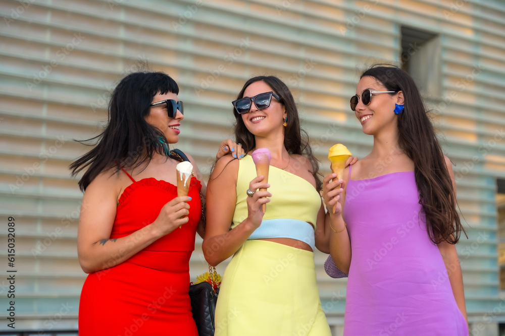 Portrait of young female friends eating ice cream on summer vacation by the beach Portrait of young female friends eating ice cream on summer vacation by the beach