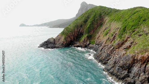 The Rocky cliff At Seashore near Orson Hotel And Resort In Con Dao, Vietnam. Aerial Drone dolly Shot photo