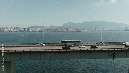 Rio de Janeiro, Brazil - 2023: Aerial panning view vehicles drive in traffic over guanabara bay on sea-crossing Rio-Niteroi bridge. Traffic tolls transportation in South America