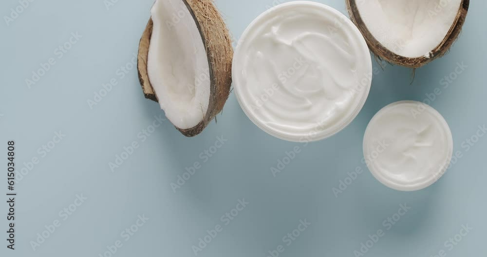 White Bottles and tubes with coconut for cosmetics rotating on a light blue background in studio. Cosmetics oils based on natural ingredients, scrub, tonic, body care. Natural cosmetics production. White Bottles and tubes with coconut for cosmetics rotating on a light blue background in studio. Cosmetics oils based on natural ingredients, scrub, tonic, body care. Natural cosmetics production.