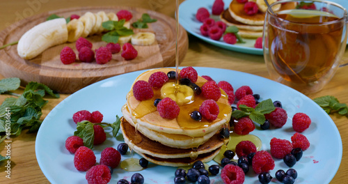 Sweet honey pouring over pancakes. Tasty breakfast food