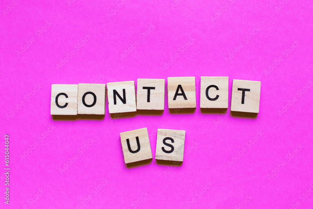 Word contact us made from wooden cubes on a pink paper background. Word contact us made from wooden cubes on a pink paper background.