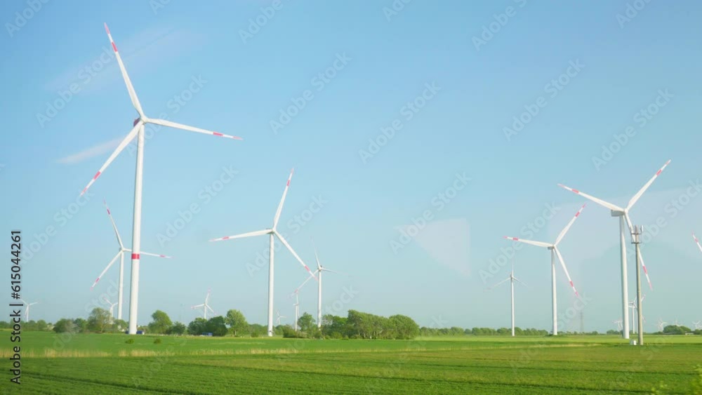 Passing by Majestic Wind Turbines in Northern Germany against blue sky. View from Train Window. Passing by Majestic Wind Turbines in Northern Germany against blue sky. View from Train Window.