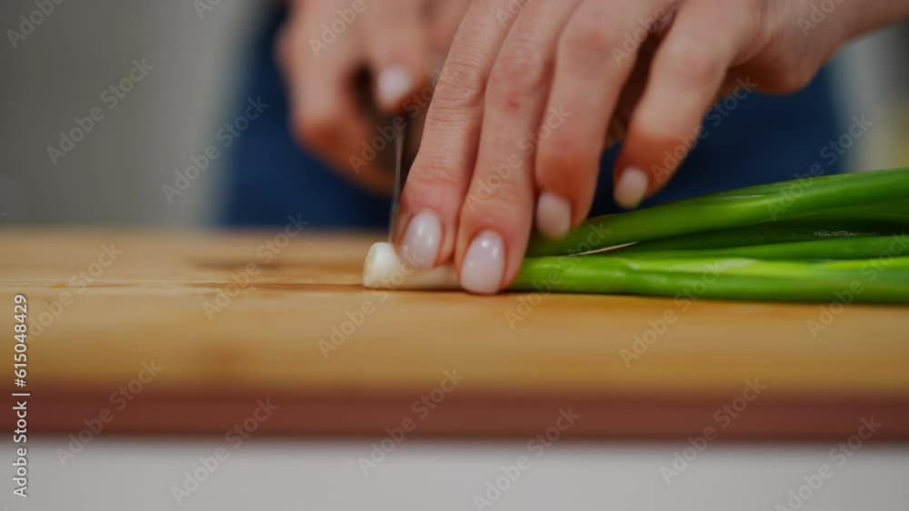 Close-up female hands start cutting green onion in slow motion with knife. Unrecognizable Caucasian woman preparing ingredient for tasty salad in kitchen closeup Close-up female hands start cutting green onion in slow motion with knife. Unrecognizable Caucasian woman preparing ingredient for tasty salad in kitchen closeup