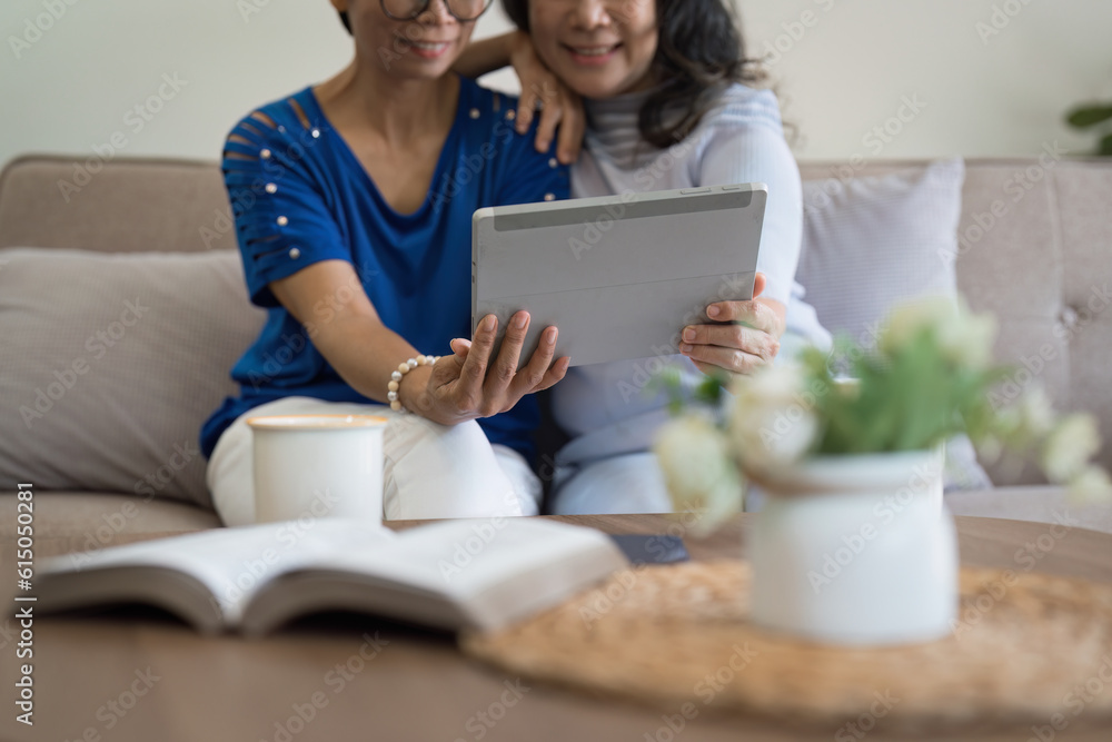 Asian elderly women and friend using social media and living room. Video streaming, happiness and conversation at a house with old people together Asian elderly women and friend using social media and living room. Video streaming, happiness and conversation at a house with old people together