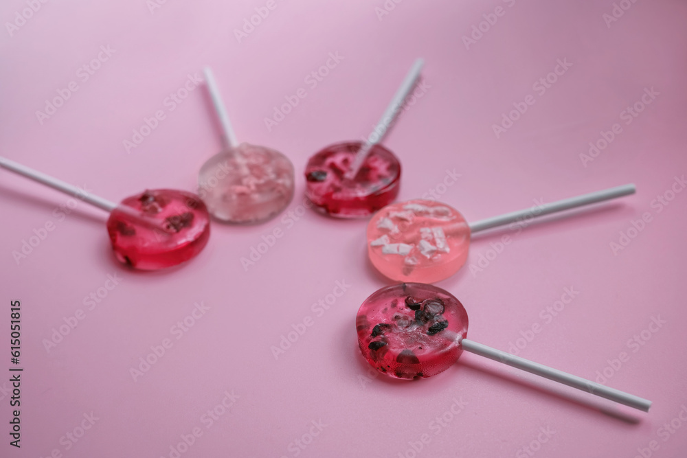 homemade fruit lollipops with pieces of fruit of different shades of pink lie in the shape of a semicircle homemade fruit lollipops with pieces of fruit of different shades of pink lie in the shape of a semicircle