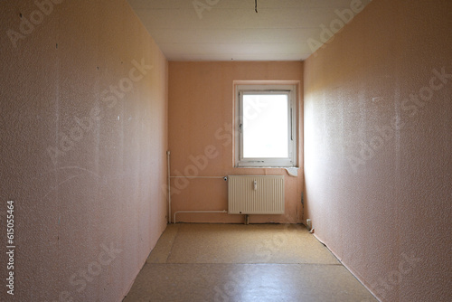 Cramped unrenovated room intended as enough space in a typical rental apartment in social housing with cheap flooring, exposed pipes and poorly insulated window, copy space