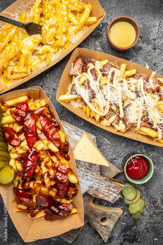 Traditional fast and street food, French fried potatoes with beef stew and mayonnaise in paper box photo