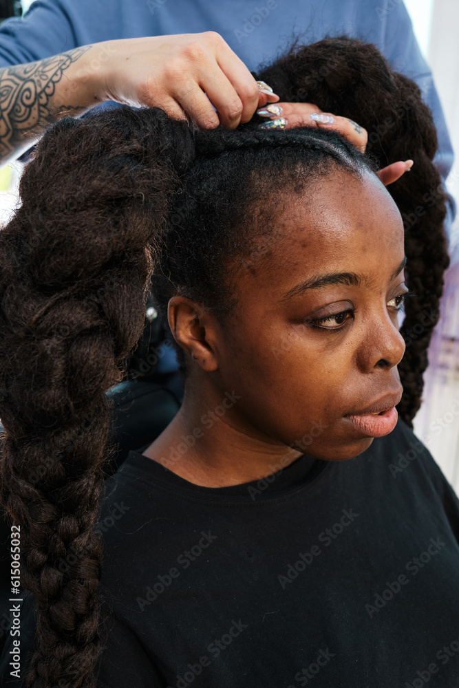 Φωτογραφία African woman in the hair salon, the hands of the hair master create voluminous