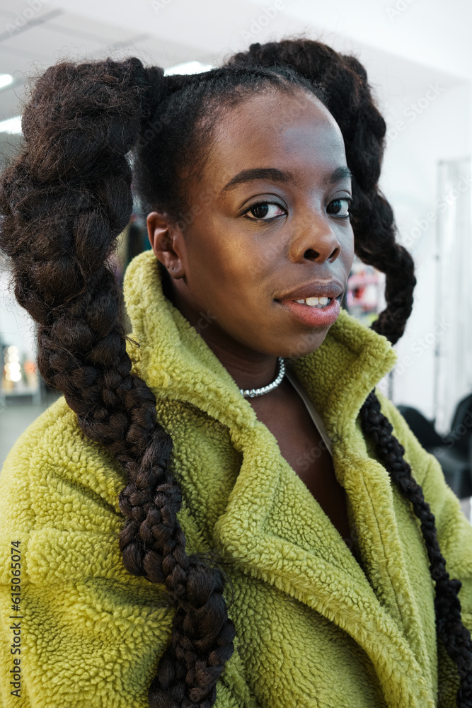 Φωτογραφία portrait of an African brat woman  with a stylish braids in a green coat