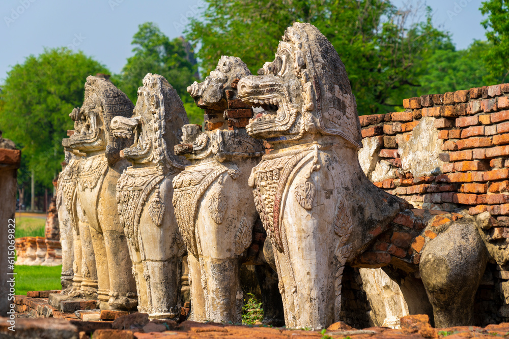 Ruined pagoda with surrounded by lion sculptures in Wat Thammikarat Ayutthaya, Thailand