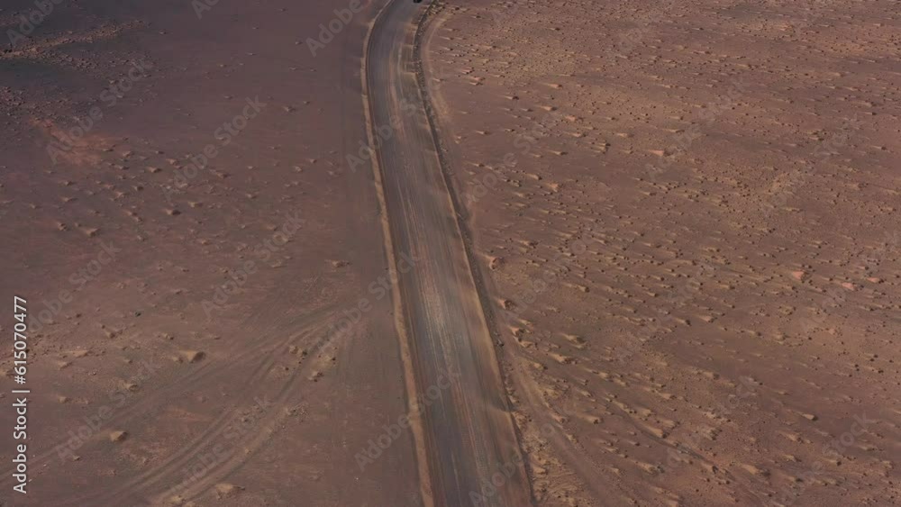 Aerial zenital view in movement over a road to the lighthouse in the coastline Aerial zenital view in movement over a road to the lighthouse in the coastline