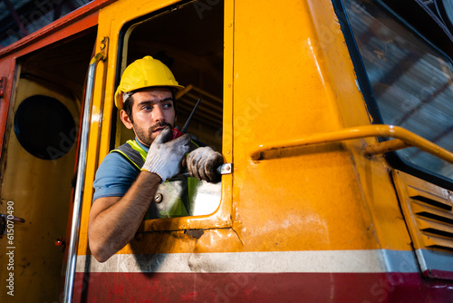 Quadro em tela A handsome train driver uses a walkie-talkie or walkie-talkie in the interior room to control the train