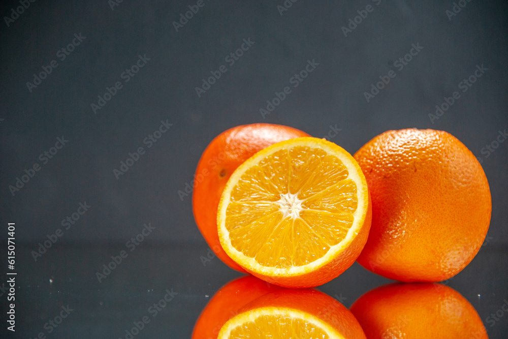 Top view of whole cut fresh oranges standing side by side on the left
