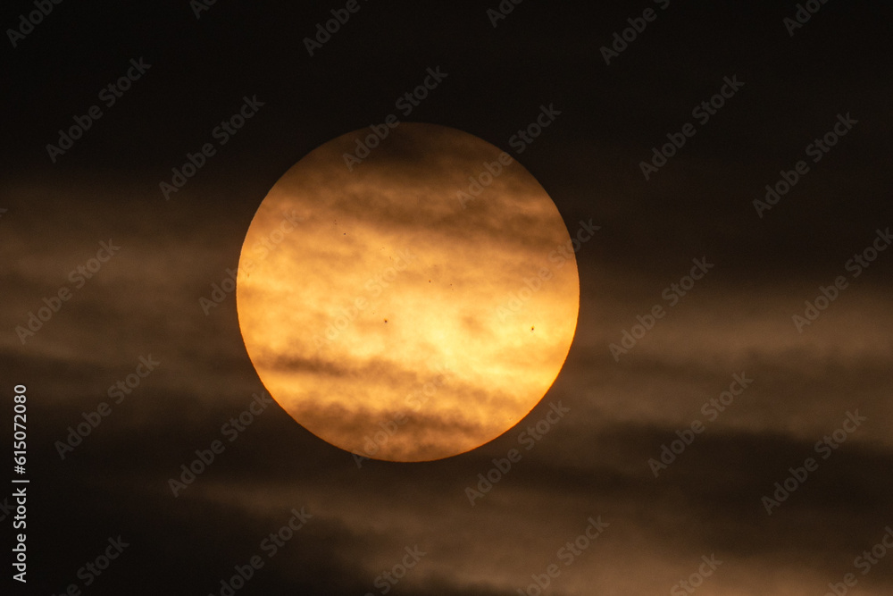 Setting sun and clouds showing sunspots 
