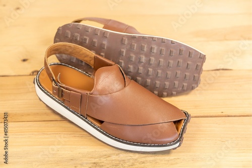 Peshawari sandal use as a formal or casual footwear in summer on wooden background closeup. photo