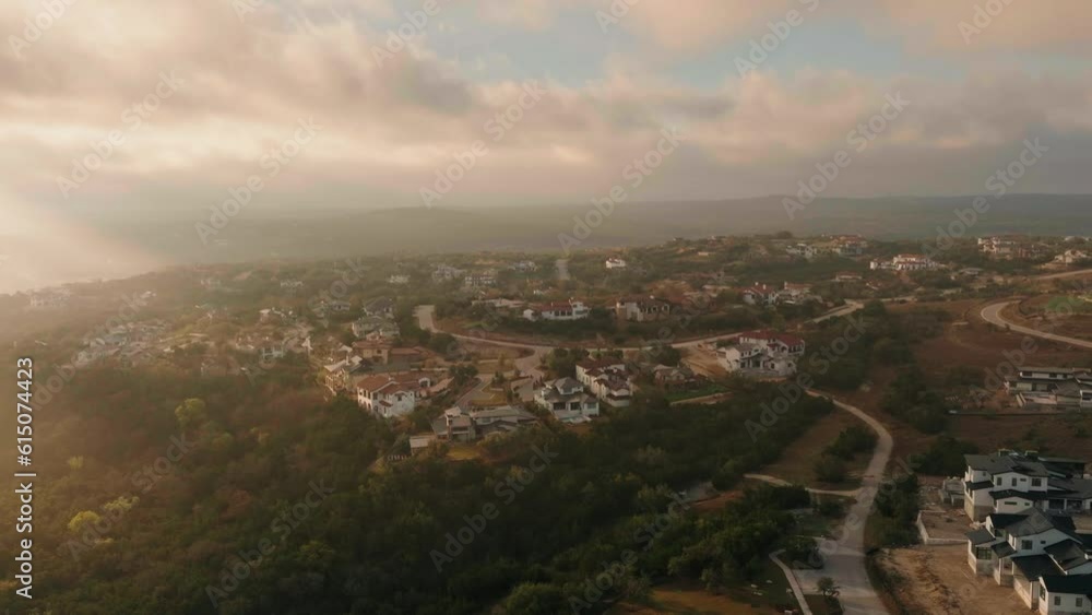 Aerial drone orbit over Austin, Texas Hill Country suburb homes during beautiful sunrise, real estate listing Aerial drone orbit over Austin, Texas Hill Country suburb homes during beautiful sunrise, real estate listing