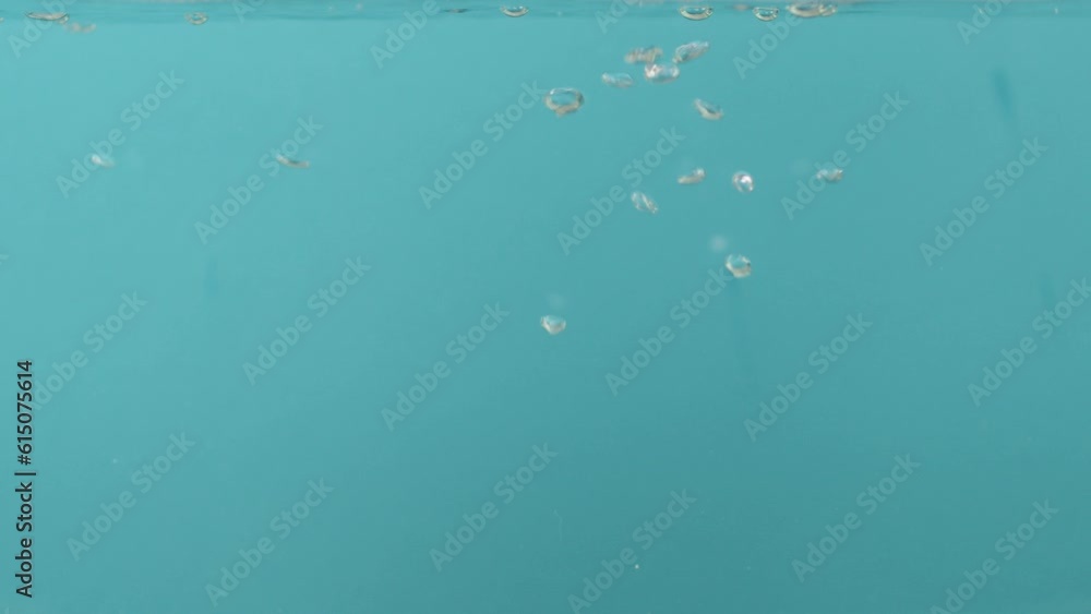 Air bubbles in the water rise upwards on a blue background. close up Air bubbles in the water rise upwards on a blue background. close up