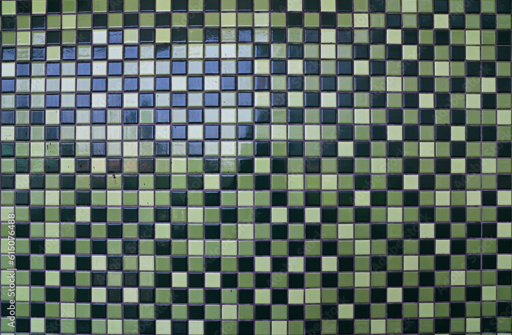 The wall is patterned with small green tone square tiles background for design and decoration at Thailand.