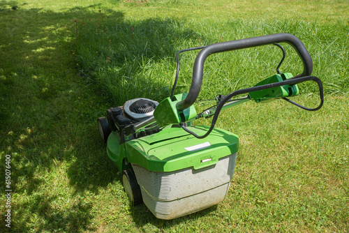 mowing the grass in the home garden with a gas lawnmower