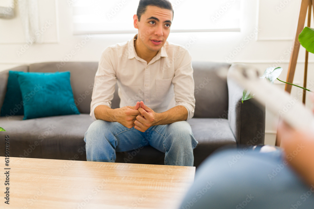 Obraz premium Depressed man patient feeling sad while talking with a psychologist