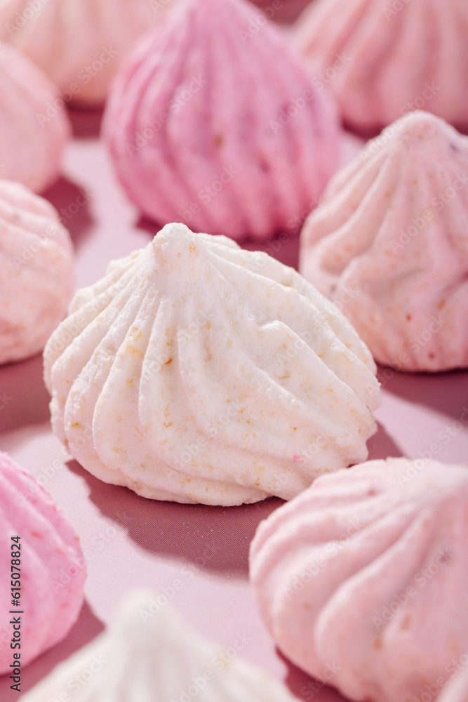 Pink meringue cookies with berry flavor on a pink background Pink meringue cookies with berry flavor on a pink background