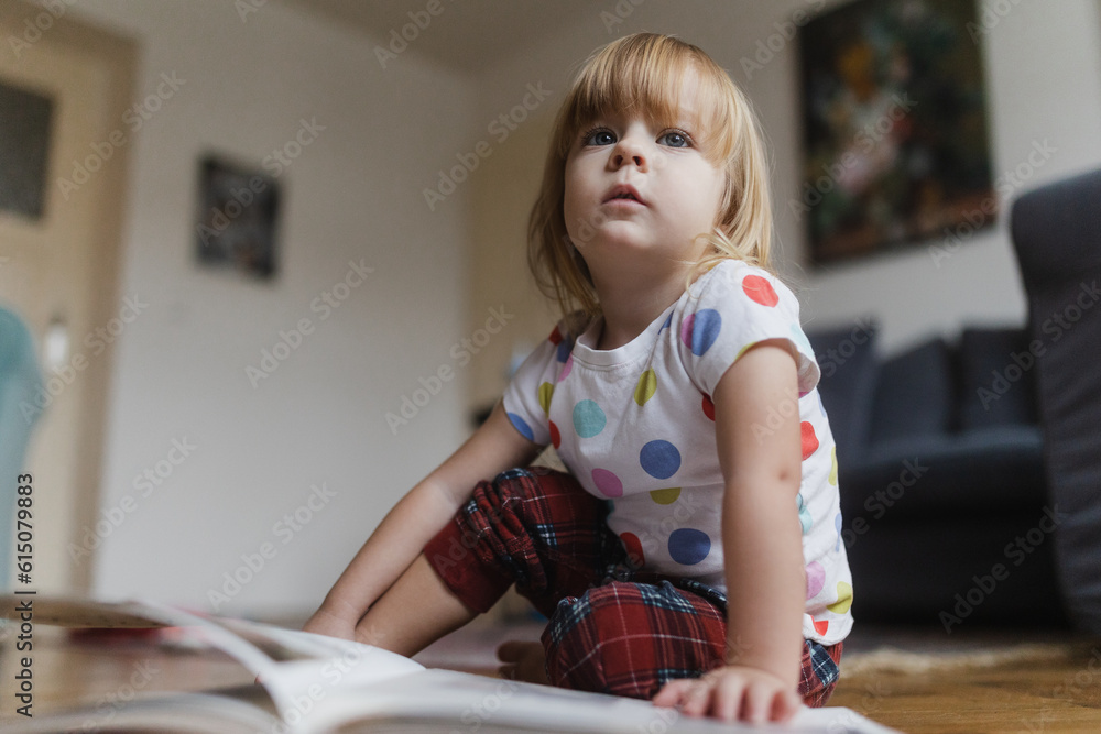 Cute little girl reading book sitting on the floor. Stock Photo | Adobe ...
