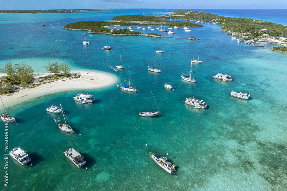 Drone aerial view of anchored sailing yacht in emerald Caribbean Sea, Stocking Island, Great Exuma, Bahamas.