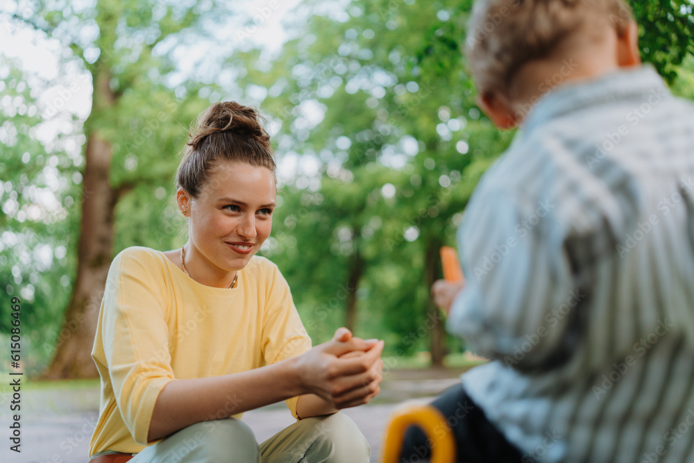 Mother feeding her son with healty snack in a park. Mother feeding her son with healty snack in a park.