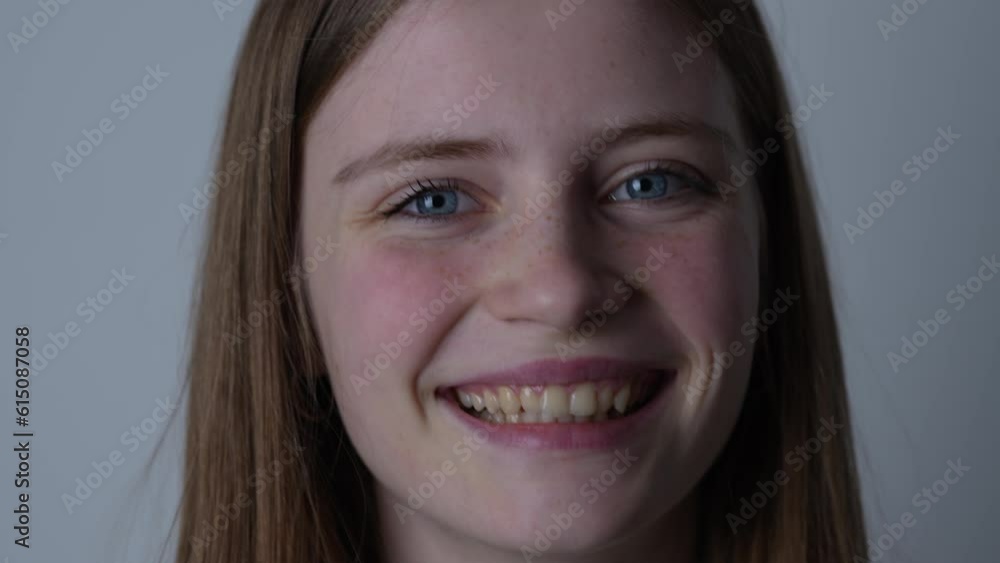 Portrait of a beautiful happy girl with blond hair and freckles looking at the camera and smiling charmingly, close up Portrait of a beautiful happy girl with blond hair and freckles looking at the camera and smiling charmingly, close up