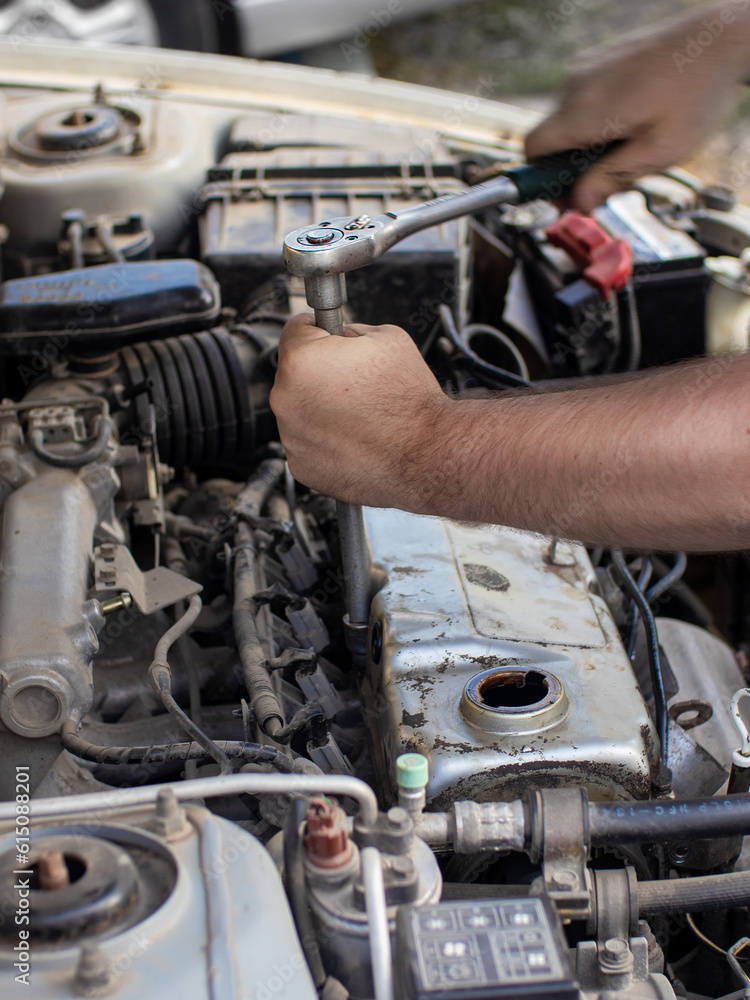 Fototapeta premium car mechanic repairing engine in garage