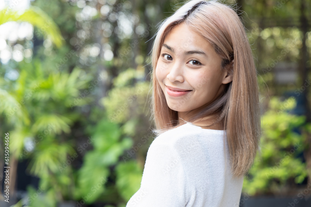 Happy smiling southeast asian woman with modern hair coloring looking back Happy smiling southeast asian woman with modern hair coloring looking back