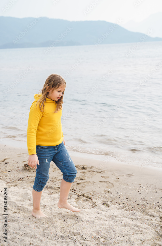 Lonely beautiful sad girl teenager sits thoughtfully on sand sea beach. Dreams,anxiety,worries about future,school friends, parents. Teen bullying, psychological problems in adolescent puberty period