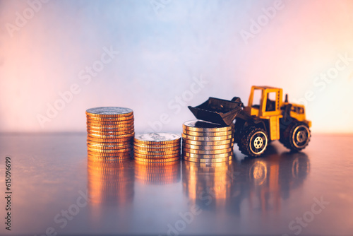 Closeup stack coins with forklift vehicle using as business and logistics industry concept