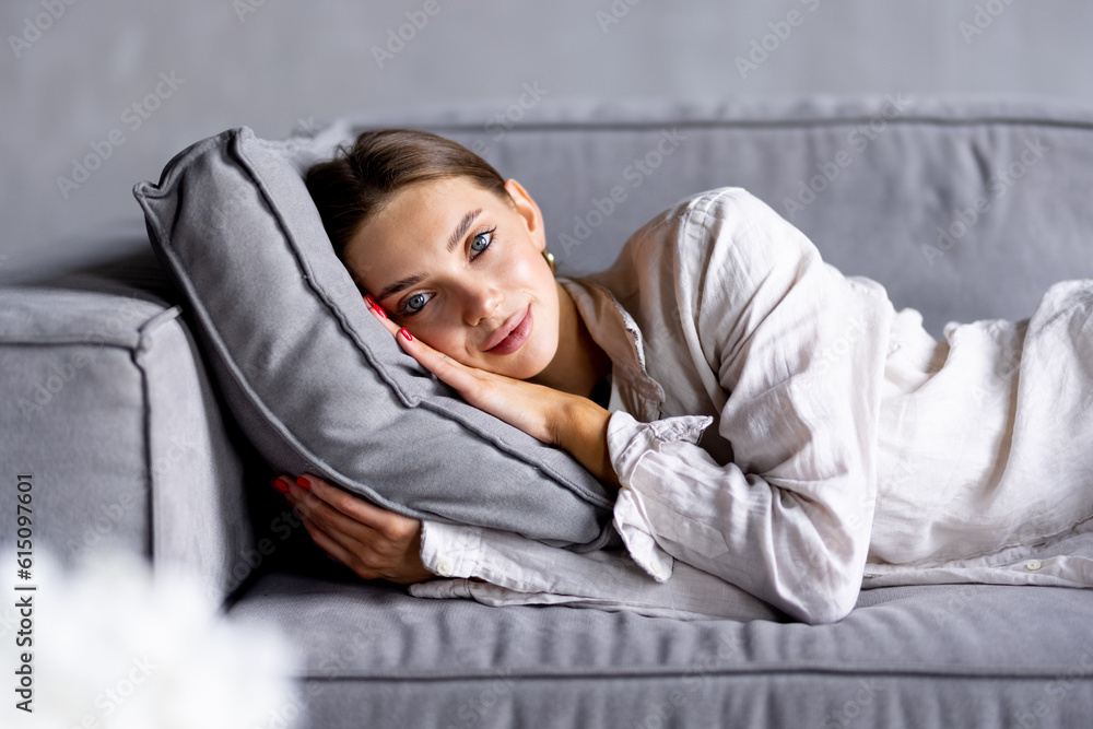 Happy young woman lying on couch and relaxing at home Happy young woman lying on couch and relaxing at home