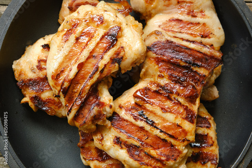 Grilled juicy chicken thigh fillets closeup. View from above.