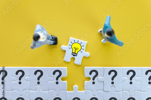 Creative thinking,Innovation,New idea for business concept.,Top view photo of a business man lookg to White jigsaw or puzzle last piece with light bulb icon use for problem solving idea. photo
